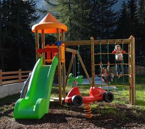 a child playing on a playground with a slide at Ferienhaus Maria Schneeglöcklein in Moso