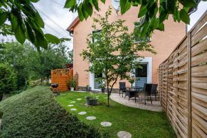 a backyard with a wooden fence and a tree at Grünzweig in Dobeneck