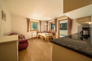 a kitchen and a living room with a table at Ferienhaus Maria Schneeglöcklein in Moso