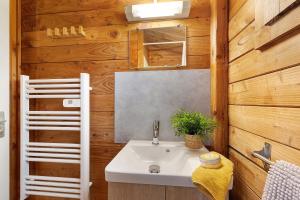 a bathroom with a white sink and wooden walls at Chalet confort 21 in Saint-Gervais