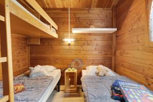 two beds in a room with wooden walls at Chalet confort 21 in Saint-Gervais