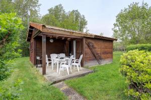 a wooden cabin with a table and chairs in the grass at Chalet confort 21 in Saint-Gervais