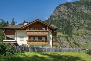 a house with a fence in front of a mountain at Ferienhaus Maria Schneeglöcklein in Moso