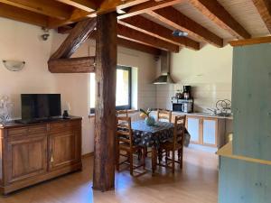 a kitchen with a table and chairs in a room at Entre Lacs et Sapins in Dortan