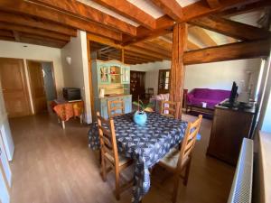 a dining room with a table and chairs and a bedroom at Entre Lacs et Sapins in Dortan +5 photos