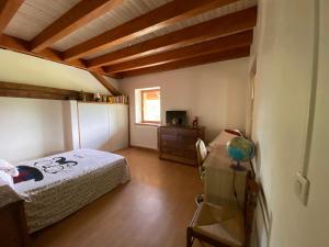 a bedroom with a bed and a desk and a window at Entre Lacs et Sapins in Dortan