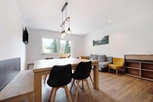 a dining room and living room with a table and chairs at Haus Mader 2 in Riscone +18 photos