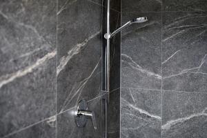 a shower with a glass door with a faucet at Haus Mader 2 in Riscone