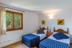 a bedroom with two beds and a window at S Estanyol in Colonia de Sant Pere