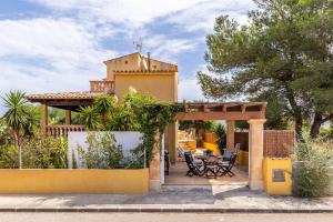 a house with a patio with a table and chairs at S Estanyol in Colonia de Sant Pere
