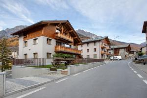 ein Gebäude mit Holzdach an einer Straße in der Unterkunft Quattropassi Bormio in Bormio