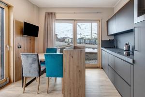 a kitchen with a wooden table and blue chairs at Chalet Kb in Livigno