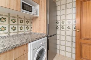a kitchen with a washing machine and a microwave at Beach and Pool Laguna Beach A113 in Torrox