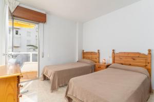 two beds in a room with a window at Beach and Pool Laguna Beach A113 in Torrox +20 photos