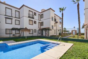 an apartment building with a swimming pool in front of a building at Beach and Pool Laguna Beach A113 in Torrox