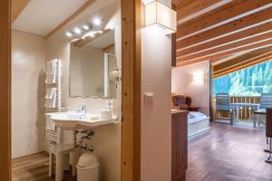 a bathroom with a sink and a mirror at Hotel Residence Gardena Dolomites in Santa Cristina Gherdëina +20 photos