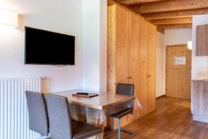 a dining room with a table and chairs and a tv at Hotel Residence Gardena Dolomites in Santa Cristina Gherdëina