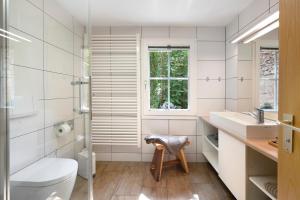 a bathroom with a toilet and a sink and a window at Gutenburghüsli mit Garten am Fluss in Weilheim +37 photos