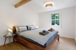 a bedroom with a bed with towels on it at Gutenburghüsli mit Garten am Fluss in Weilheim
