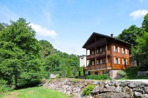 a house on a hill with a stone wall at Gutenburghüsli mit Garten am Fluss in Weilheim