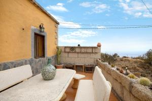 a table with chairs and a vase sitting on a patio at Casa Candelaria in Arico