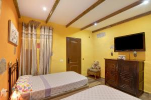 a bedroom with a bed and a flat screen tv at Casa Candelaria in Arico