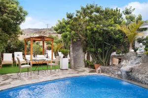 a pool with a table and chairs next to a house at Casa Candelaria in Arico