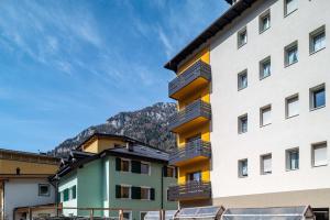 a building with balconies and mountains in the background at Casa Mara in Predazzo