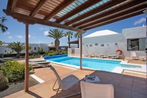 a villa with a swimming pool and a patio at Casa Margarita in Lanzarote