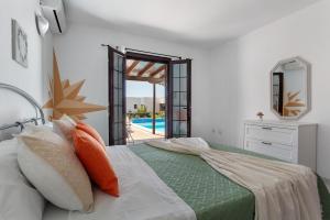 a bedroom with a bed and a view of a pool at Casa Margarita in Lanzarote +28 photos
