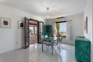 a dining room with a green table and chairs at Casa Margarita in Lanzarote