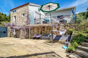 a house with a patio and an umbrella at Casa Azul in Moledo