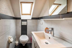 a small bathroom with a sink and a toilet at Nordsee Ferienwohnung Möwe in Thunum