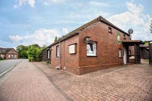 a brick building on the side of a street at Nordsee Ferienwohnung Möwe in Thunum