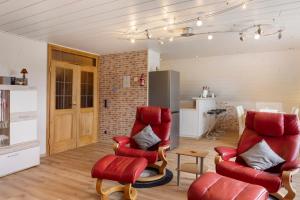 a living room with two red chairs and a kitchen at Haus Claudia in Fulda