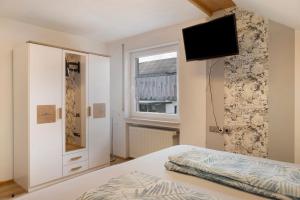 a bedroom with a bed and a television on a wall at Haus Claudia in Fulda