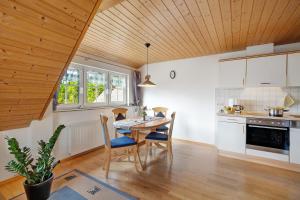 a kitchen with a wooden ceiling and a table and chairs at Baschijörgenhof in Sankt Peter