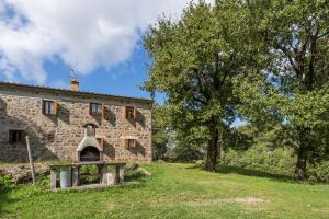 an old stone building with an oven in a yard at App.to Colline - Casetta di Ugolino in Radicofani