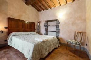 a bedroom with a bed and a chair in a room at App.to Colline - Casetta di Ugolino in Radicofani
