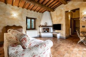 a living room with a couch and a television at App.to Colline - Casetta di Ugolino in Radicofani
