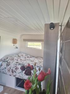 ein Schlafzimmer mit einem Bett und einer Vase mit Blumen in der Unterkunft Westerhoeve in Petten