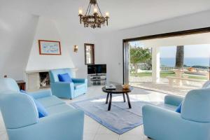a living room with blue chairs and a table at Villa Brigida in Patroves