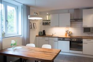 a kitchen with a wooden table and white cabinets at Ferienwohnung Auszeit in Salem