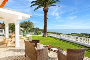 a patio with a table and chairs and a palm tree at Villa Brigida in Patroves
