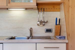 a kitchen counter with a sink and utensils at Paracia App Pec in Badia