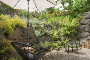 a patio with two chairs and an umbrella at Ferienwohnung Auszeit in Salem