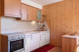 a kitchen with white appliances and wooden cabinets at Paracia App Pec in Badia +19 photos