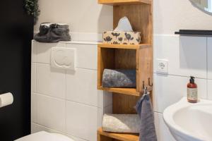 a bathroom with wooden shelves next to a sink at Ferienwohnung Auszeit in Salem +15 photos