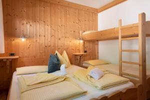 two bunk beds in a room with wooden walls at Paracia App Pec in Badia
