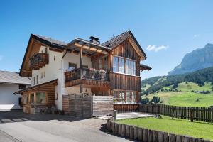 a wooden house with a balcony in the mountains at Paracia App Pec in Badia